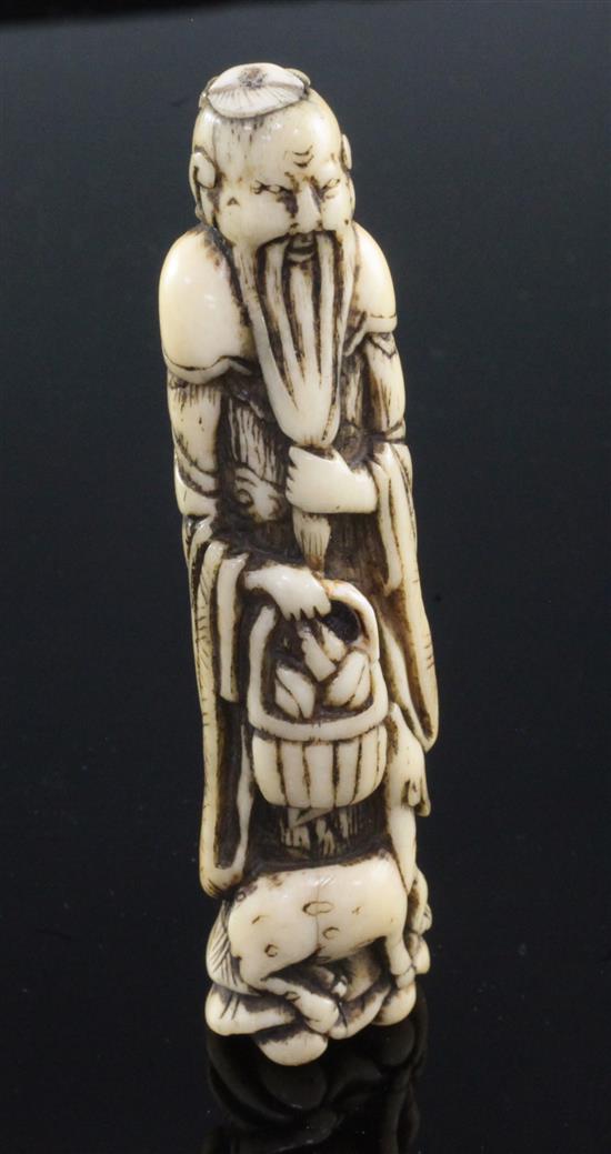 A Japanese stag antler netsuke of a standing sennin, Edo period, 9.8cm